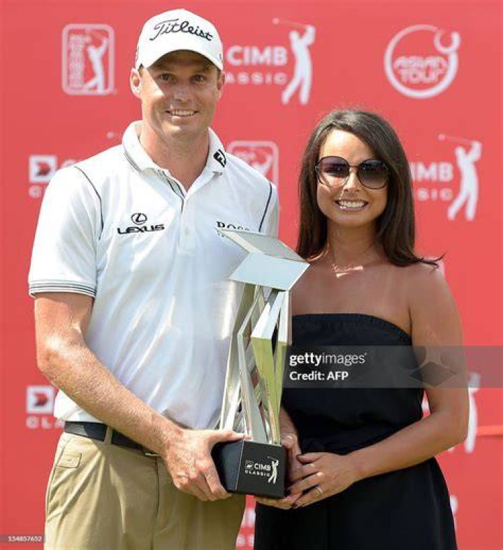 Nick Watney (L) of the US and his wife Amber Watney (R) pose with the